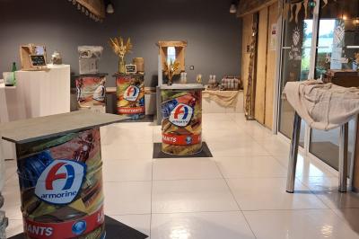 Salle décorée avec des fûts recyclés en tables, éclairage chaleureux et éléments rustiques en bois.