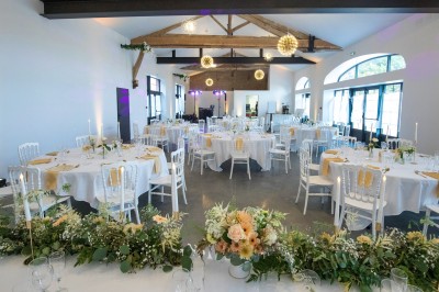 Deux mains tendues l'une vers l'autre au-dessus d'un champ de tournesols fanés.
