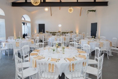 Deux mains tendues l'une vers l'autre au-dessus d'un champ de tournesols fanés.