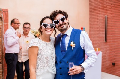 Deux mains tendues l'une vers l'autre au-dessus d'un champ de tournesols fanés.
