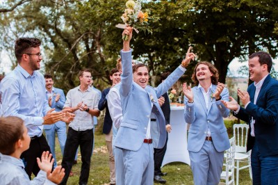 Deux mains tendues l'une vers l'autre au-dessus d'un champ de tournesols fanés.