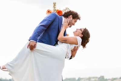 Deux mains tendues l'une vers l'autre au-dessus d'un champ de tournesols fanés.