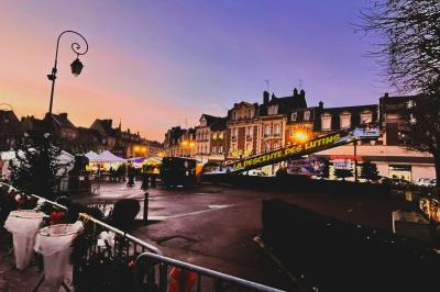 Foule dansante lors d'un événement nocturne en extérieur, éclairée par des lumières colorées.