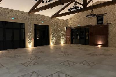 Entrée avec porte vitrée, mur végétal à droite, sol en béton et éclairage au sol.