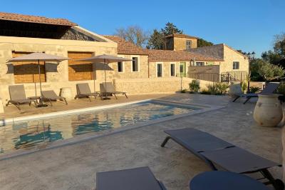 Entrée avec porte vitrée, mur végétal à droite, sol en béton et éclairage au sol.