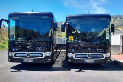 Miniature Mooland #4 Deux bus noirs Mercedes stationnés côte à côte sur un parking, avec un paysage montagneux en arrière-plan.