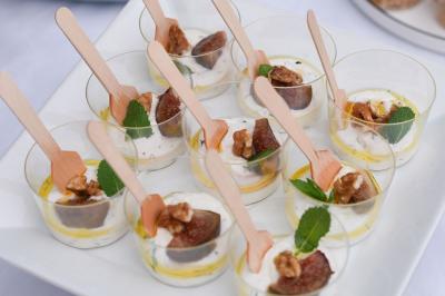 Miniature Traiteur Cannes (Alpes-Maritimes) - Concept Catering Events  #31 Verrines de fromage frais garnies de figues, noix, feuilles de menthe et cuillères en bois sur un plateau blanc.