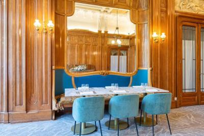 Miniature Location salle Lyon 2 (Rhône) - Mercure Lyon Centre Château Perrache #5 Chambre d'hôtel avec lit double, mur bleu, fauteuil rouge, table basse et décoration murale en forme de main.