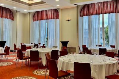 Miniature Location salle Lyon 2 (Rhône) - Mercure Lyon Centre Château Perrache #6 Chambre d'hôtel avec lit double, mur bleu, fauteuil rouge, table basse et décoration murale en forme de main.