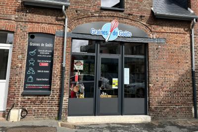 Deux femmes souriantes en tablier, l'une tenant une spatule rouge, l'autre un batteur électrique, dans une cuisine.