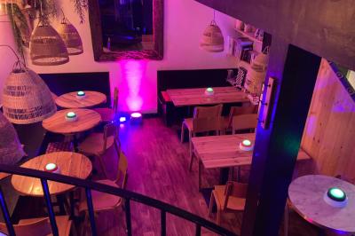 Des personnes rient et participent à une activité conviviale dans un espace chaleureux avec une ambiance lumineuse colorée.