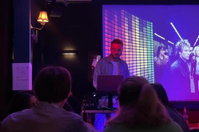 Des personnes rient et participent à une activité conviviale dans un espace chaleureux avec une ambiance lumineuse colorée.