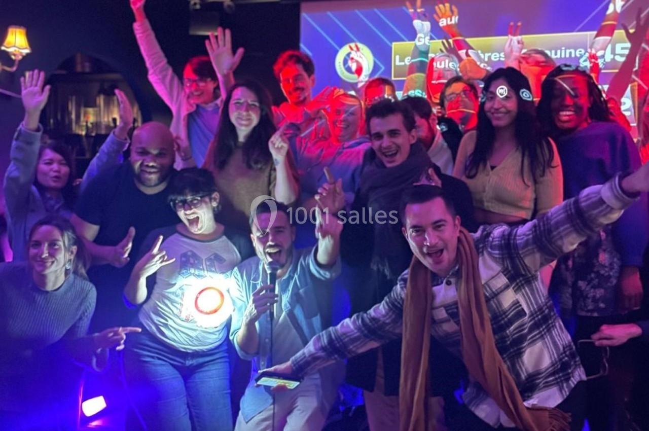 Un groupe de personnes souriantes posant ensemble dans un environnement lumineux et festif.