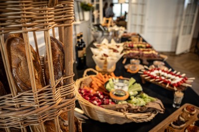 Miniature Traiteur Paris 9 (Paris) - Le 17.45 Paris #3 Buffet avec paniers de pain, légumes frais, brochettes et autres plats disposés sur une table dans un cadre intérieur.