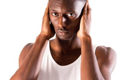 Voiture sportive bleue stationnée sur une place pavée devant un monument en bronze et des bâtiments historiques.
