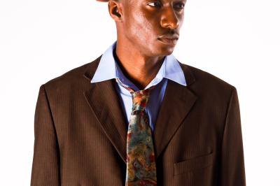 Voiture sportive bleue stationnée sur une place pavée devant un monument en bronze et des bâtiments historiques.