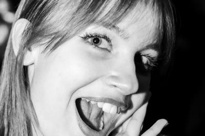 Voiture sportive bleue stationnée sur une place pavée devant un monument en bronze et des bâtiments historiques.