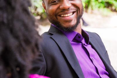 Voiture sportive bleue stationnée sur une place pavée devant un monument en bronze et des bâtiments historiques.