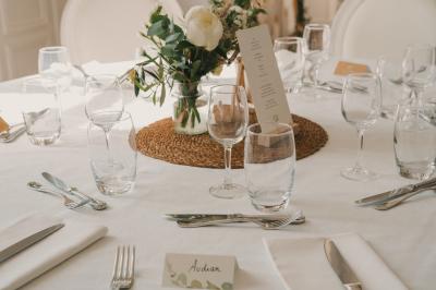 Miniature Location salle Tréflévénez (Finistère) - Château de Kérézellec #3 Un couple de mariés marche vers un château en pierre avec des volets blancs, entouré de quelques invités.