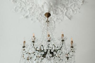 Miniature Location salle Tréflévénez (Finistère) - Château de Kérézellec #4 Un couple de mariés marche vers un château en pierre avec des volets blancs, entouré de quelques invités.