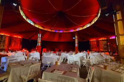 Assiette gastronomique avec un jarret d'agneau, purée de patate douce, gratin et fleurs comestibles, sur une nappe blanche.