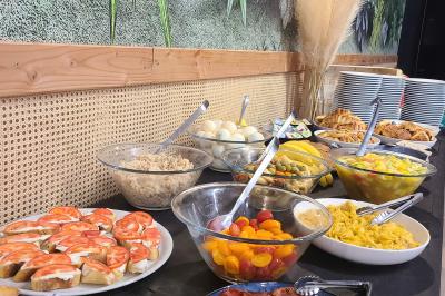 Assiette gastronomique avec un jarret d'agneau, purée de patate douce, gratin et fleurs comestibles, sur une nappe blanche.