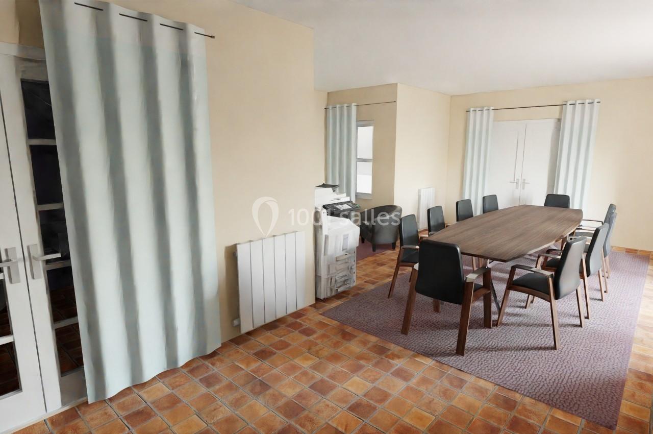 Salle de réunion avec table en bois, chaises noires, rideaux clairs et sol en carrelage.