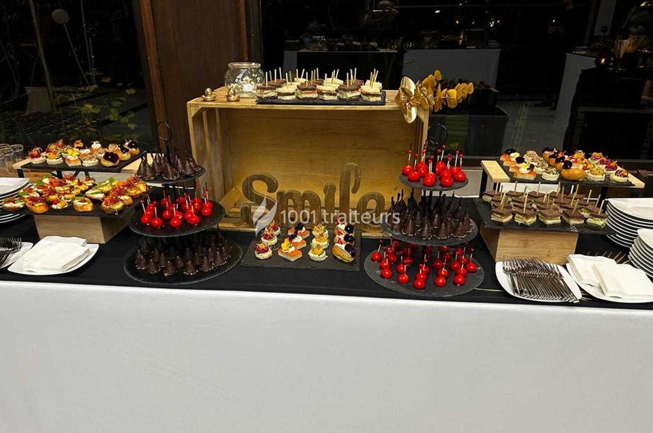 Buffet de desserts variés avec gâteaux, brochettes sucrées et verrines, présenté sur une table décorée.