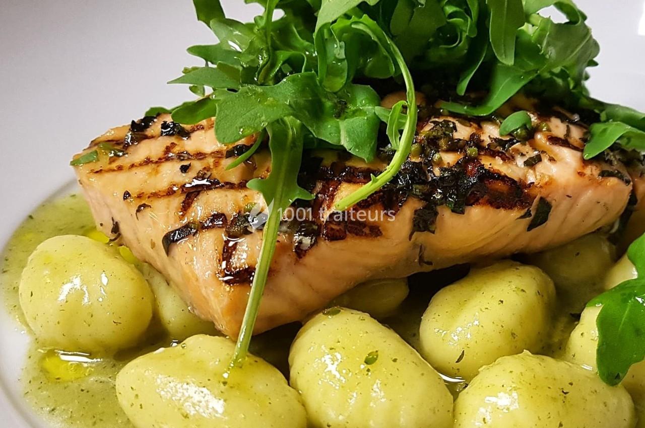 Filet de saumon grillé sur lit de gnocchis nappés de sauce verte, garni de roquette fraîche.