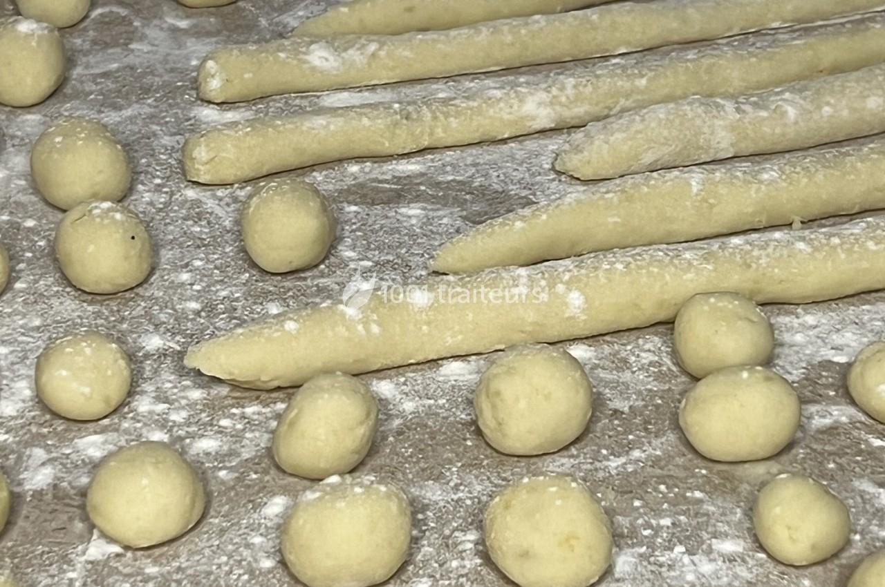 Boules et rouleaux de pâte crue disposés sur une surface farinée avant la cuisson ou la préparation.