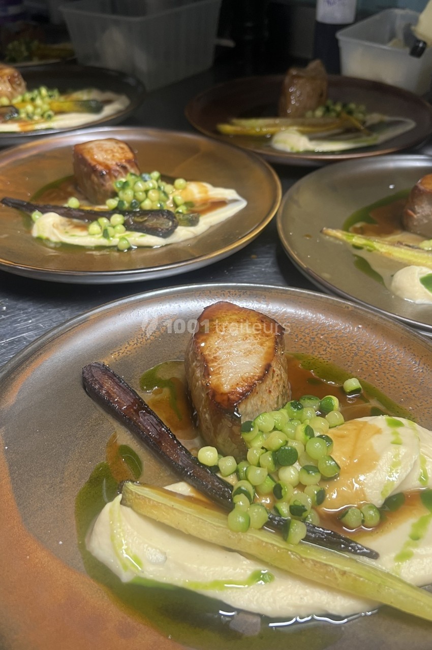 Assiette gastronomique avec viande grillée, purée, légumes verts, carotte et sauce dressés avec soin.