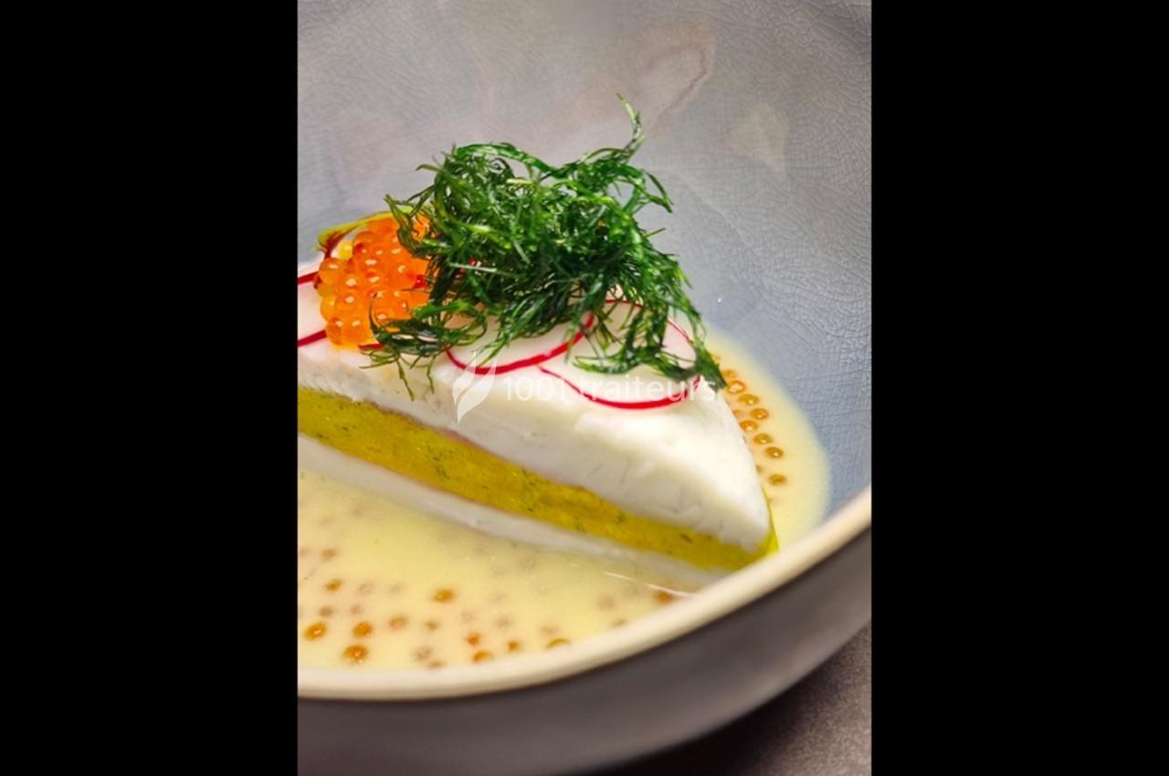 Part de poisson blanc sur purée jaune, garnie d'œufs de poisson, radis, aneth, servie dans une sauce crémeuse.