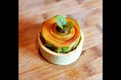 Assiette gastronomique avec saumon, mousse blanche, herbes fraîches et sauce jaune décorée de points verts.