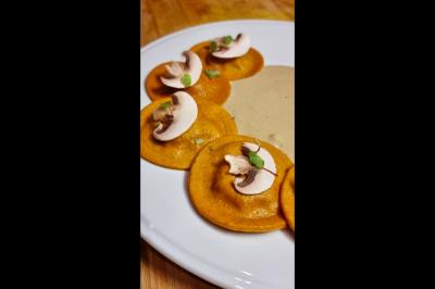 Assiette gastronomique avec saumon, mousse blanche, herbes fraîches et sauce jaune décorée de points verts.
