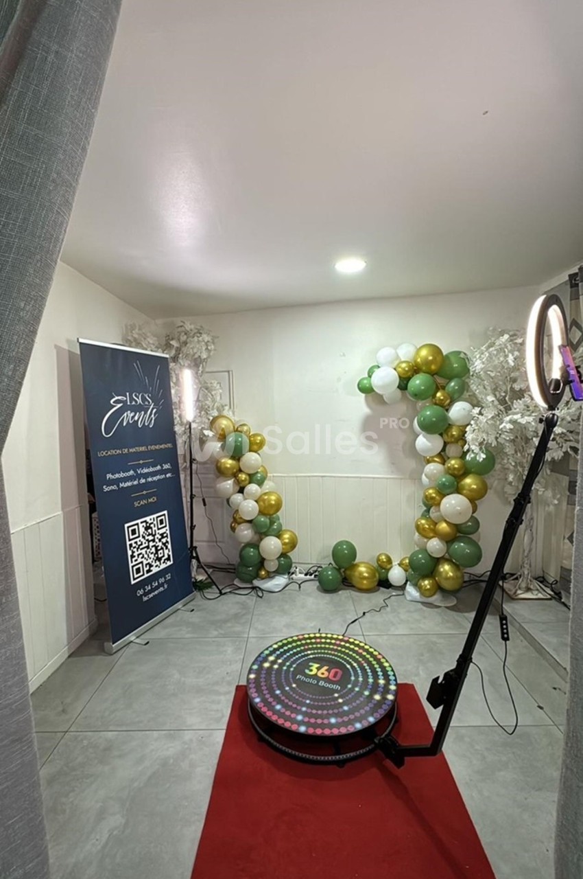 Décoration événementielle avec ballons verts, blancs et dorés, tapis rouge et plateforme 360° dans une salle lumineuse.