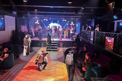 Miniature DJ Paris 5 (Paris) - Sergio Bekam #9 Un homme et une femme posent ensemble dans un environnement sombre, la femme tenant un verre à la main.