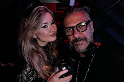 Miniature DJ Paris 5 (Paris) - Sergio Bekam #14 Un homme et une femme posent ensemble dans un environnement sombre, la femme tenant un verre à la main.