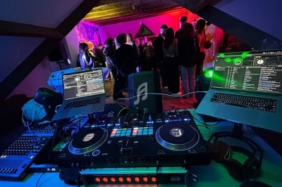 Texte écrit sur un miroir entouré d'une lumière rose, avec des décorations dorées et une table en arrière-plan.