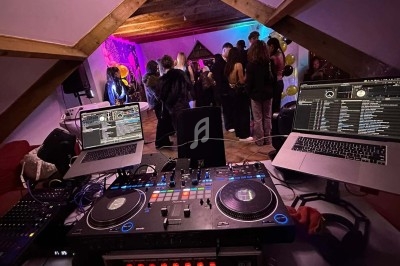 Texte écrit sur un miroir entouré d'une lumière rose, avec des décorations dorées et une table en arrière-plan.