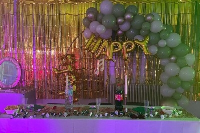 Texte écrit sur un miroir entouré d'une lumière rose, avec des décorations dorées et une table en arrière-plan.