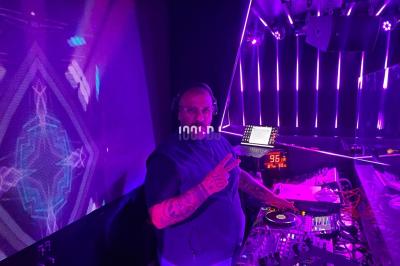 Miniature DJ Paris 5 (Paris) - Sergio Bekam #5 Un DJ portant un bonnet mixe de la musique sur une table de mixage dans un espace décoré pour les fêtes.