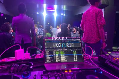 Miniature DJ Paris 5 (Paris) - Sergio Bekam #13 Un DJ portant un bonnet mixe de la musique sur une table de mixage dans un espace décoré pour les fêtes.