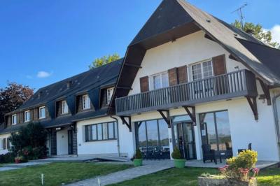 Miniature Location salle Le Teilleul (Manche) - Le Grand Gîte du Lac #14 Baby-foot en bois clair avec pieds noirs, situé dans une pièce au sol sombre et murs clairs avec une porte grise.