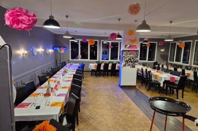 Miniature Location salle Le Teilleul (Manche) - Le Grand Gîte du Lac #4 Baby-foot en bois clair avec pieds noirs, situé dans une pièce au sol sombre et murs clairs avec une porte grise.