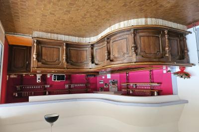 Miniature Location salle Le Teilleul (Manche) - Le Grand Gîte du Lac #15 Baby-foot en bois clair avec pieds noirs, situé dans une pièce au sol sombre et murs clairs avec une porte grise.