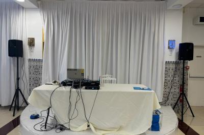 Borne photo équipée d'un appareil photo reflex et d'un anneau lumineux, placée devant une porte entrouverte.