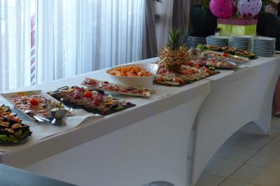 Plateau de fruits variés avec pastèque, ananas, raisins et fraises, disposés sur une table décorée.