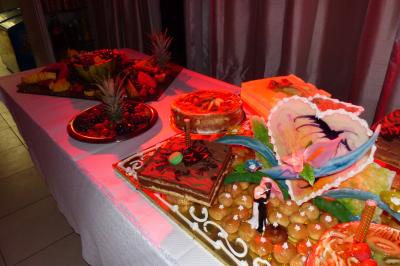 Plateau de fruits variés avec pastèque, ananas, raisins et fraises, disposés sur une table décorée.