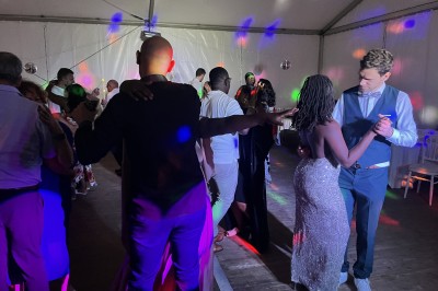 Miniature DJ Argentré-du-Plessis (Ille-et-Vilaine) - Kondo Event's #14 Des personnes dansent sous une tente éclairée par des lumières colorées, avec une table de mixage au premier plan.