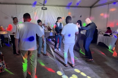 Miniature DJ Argentré-du-Plessis (Ille-et-Vilaine) - Kondo Event's #16 Des personnes dansent sous une tente éclairée par des lumières colorées, avec une table de mixage au premier plan.